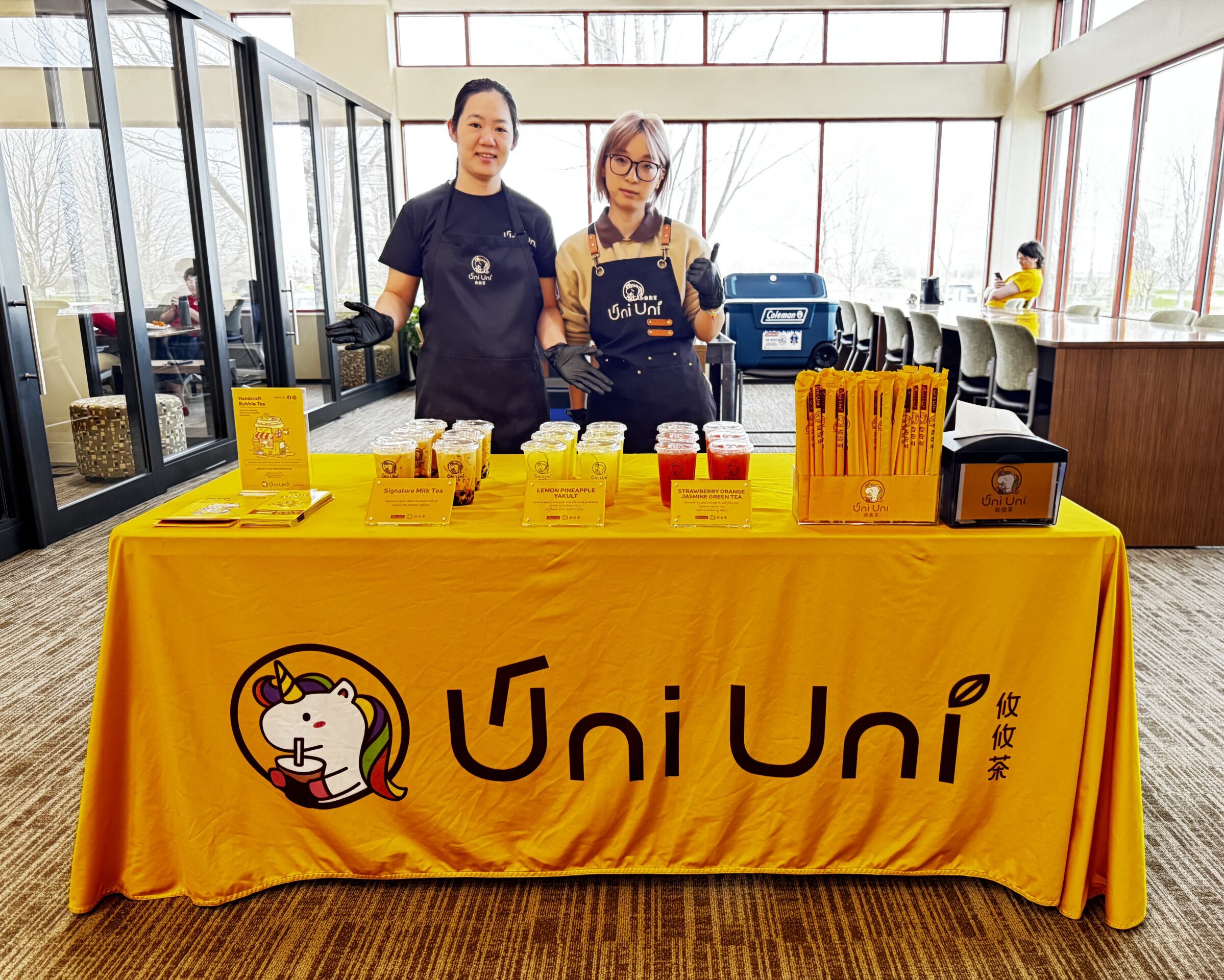 Uni Uni Boba tea stand with two staff members at a promotional event.