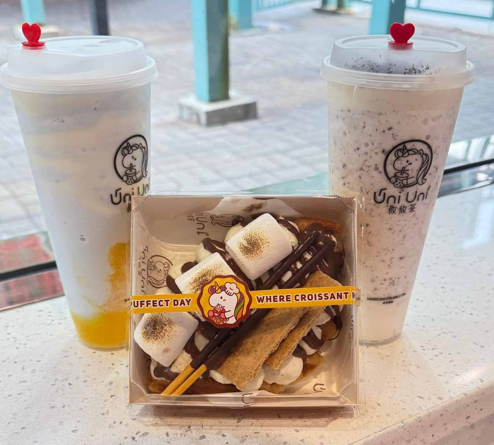 Two boba drinks and a dessert with marshmallows and chocolate.